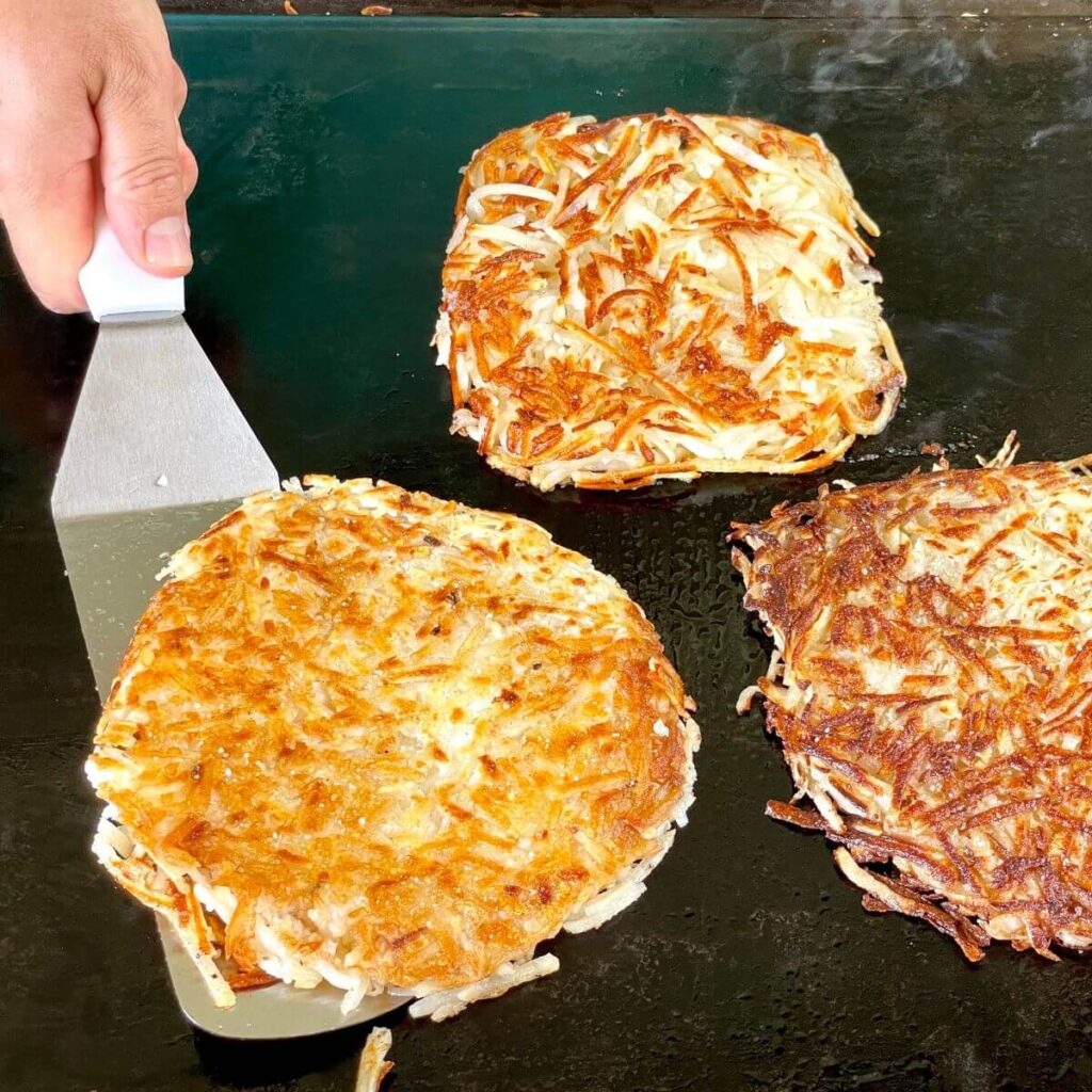 cooking griddle hash browns on a Blackstone griddle