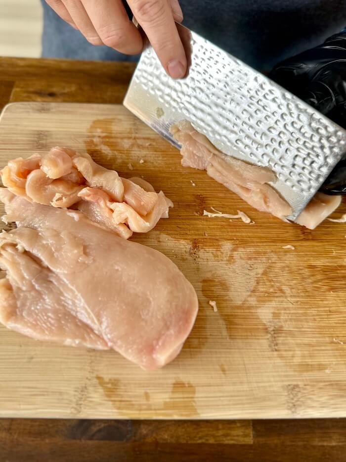 slicing chicken breasts into strips against the grain