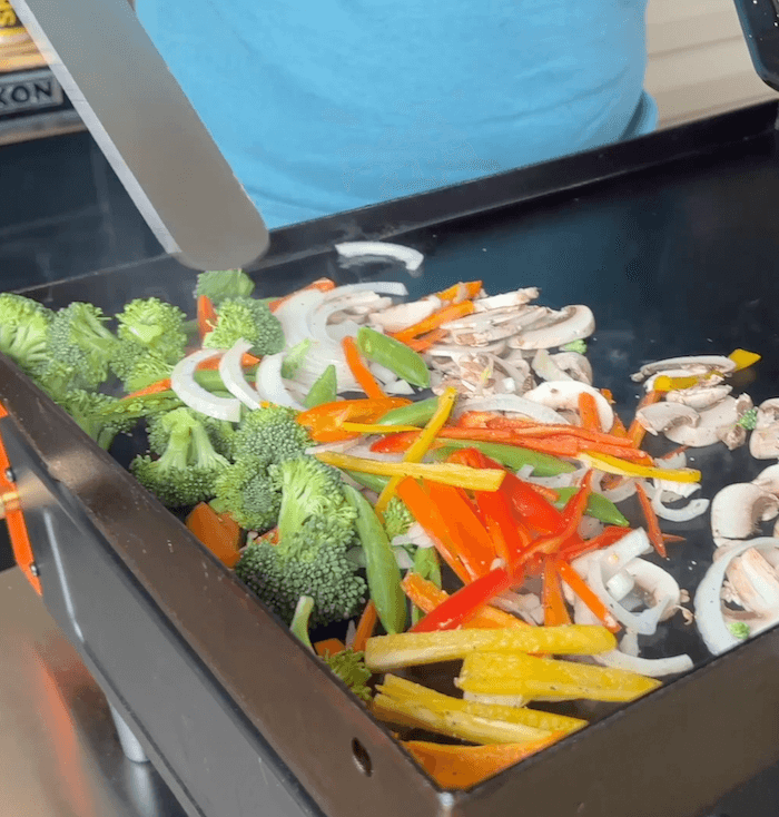 cooking stir fry vegetables on the Blackstone griddle