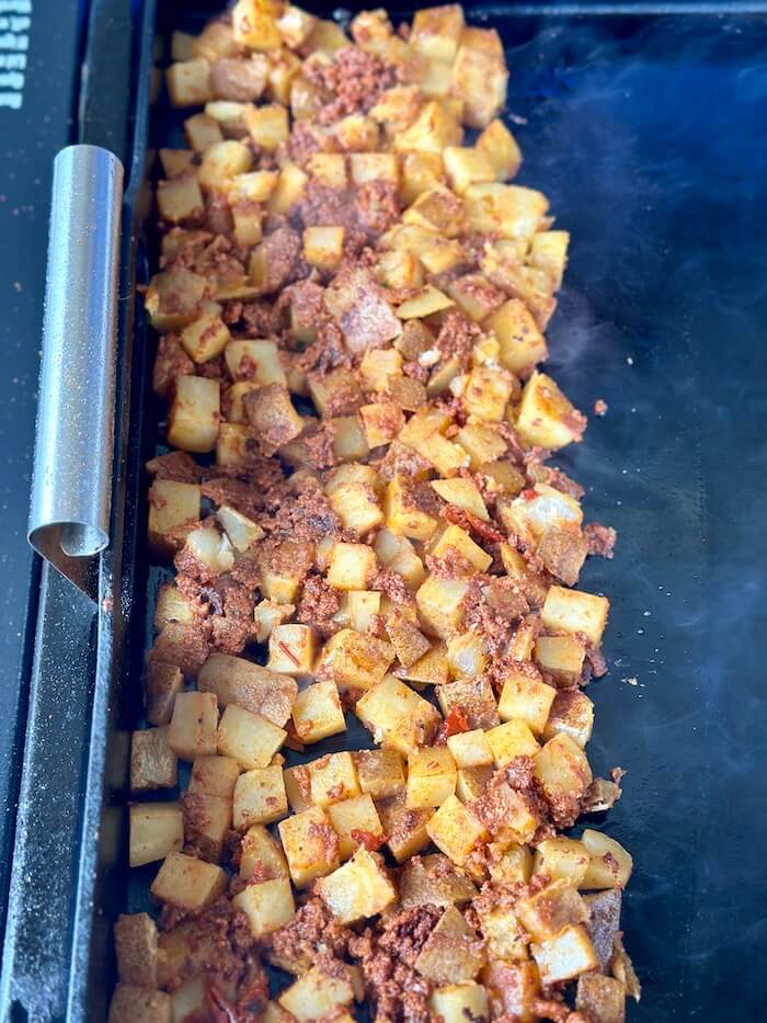 Mexican potatoes with chorizo cooking on the griddle