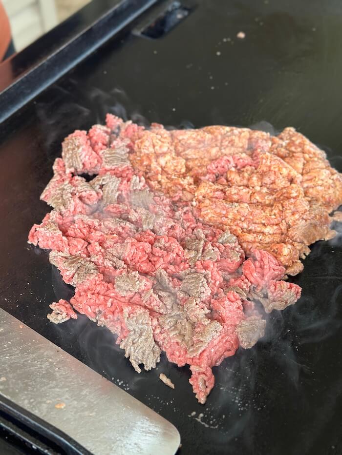 cooking ground meat on a flat top grill