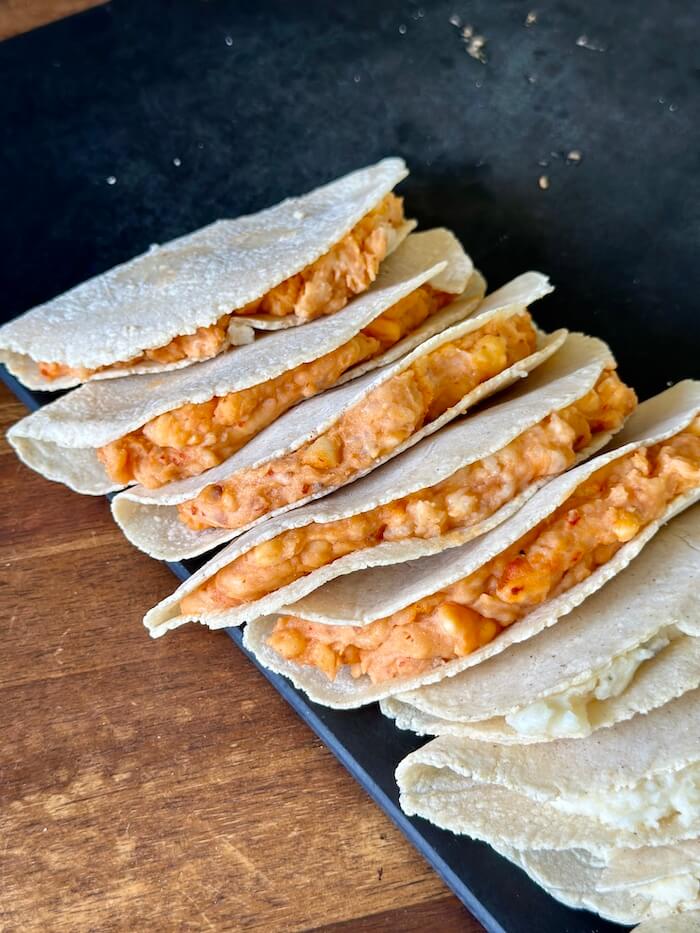 corn tortillas folded in half with Mexican mashed potatoes inside