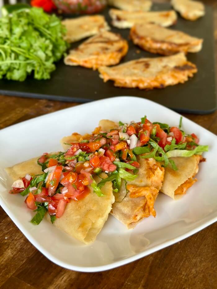 potato tacos on a plate with salsa and shredded lettuce