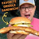 man holding a fried pork tenderloin sandwich