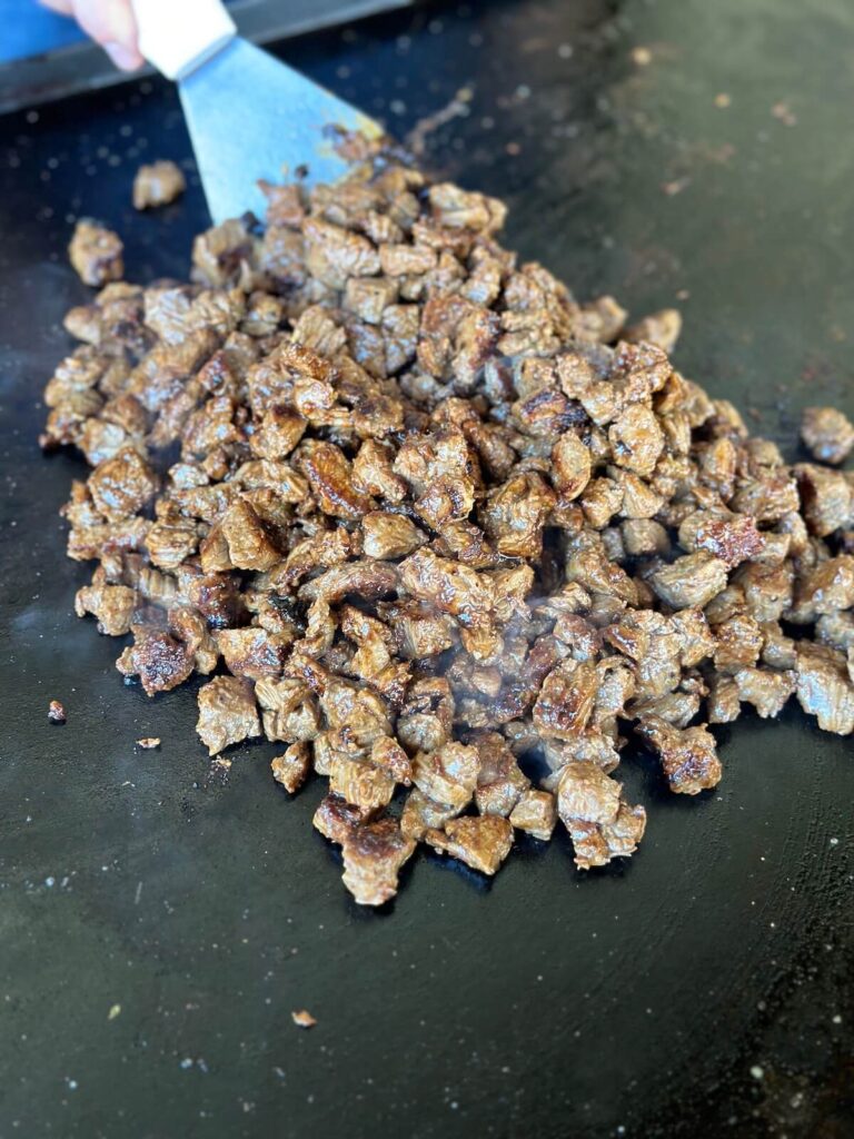 cooking carne asada steak on the griddle