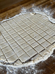 rolled out dumpling dough cut into squares