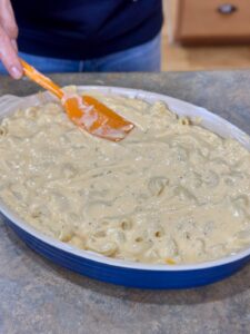 layering macaroni and cheese in a casserole dish