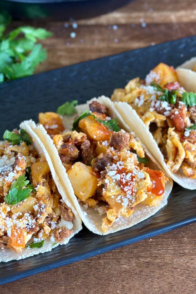 chorizo breakfast tacos with scrambled eggs and potatoes garnished with cilantro