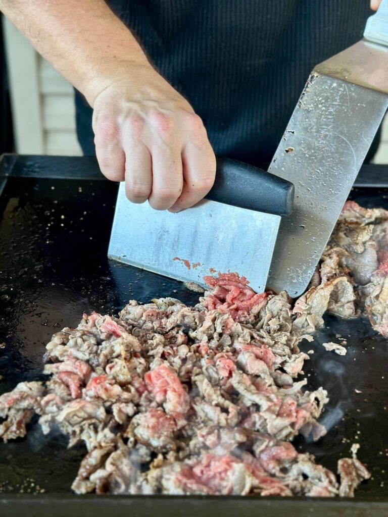 chopping ribeye steak for philly cheesesteak sliders