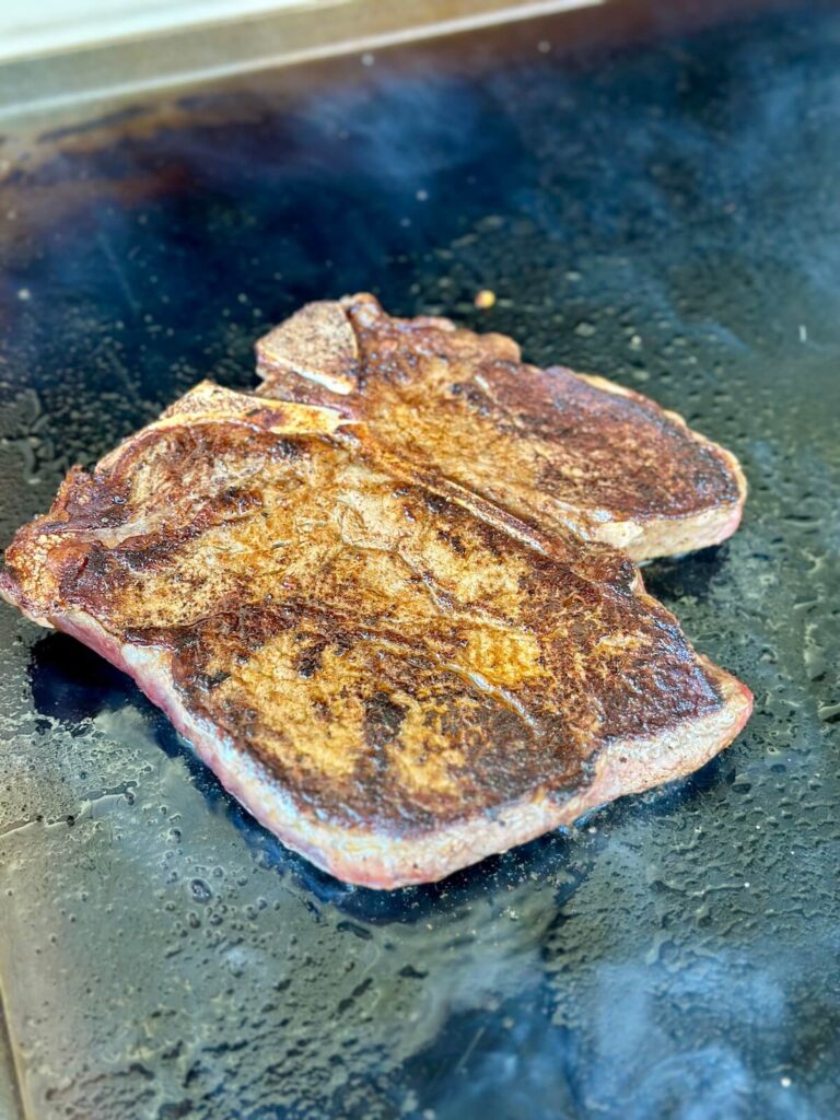 cooking a steak on the griddle