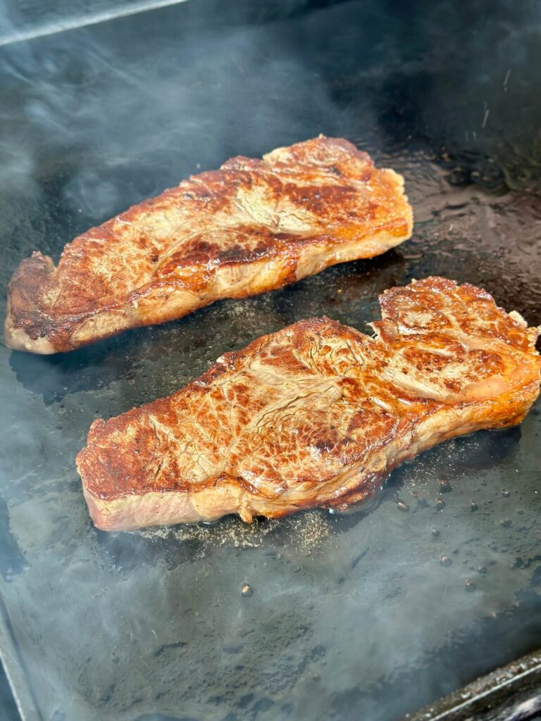 searing steaks on a griddle