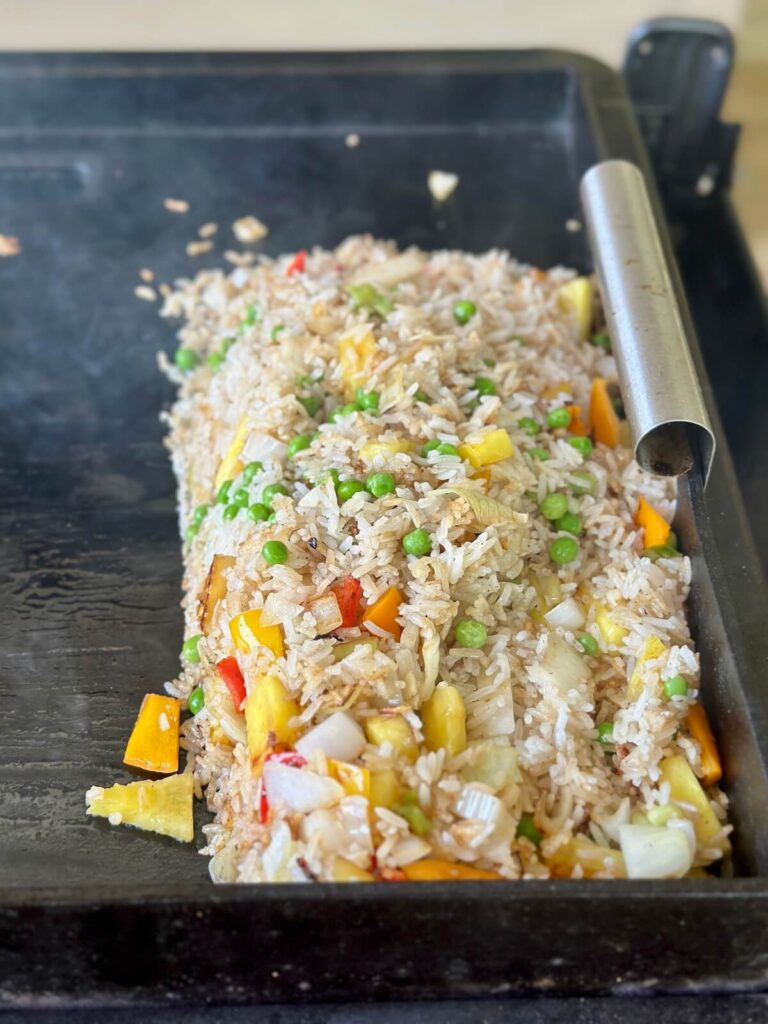making coconut fried rice on a griddle