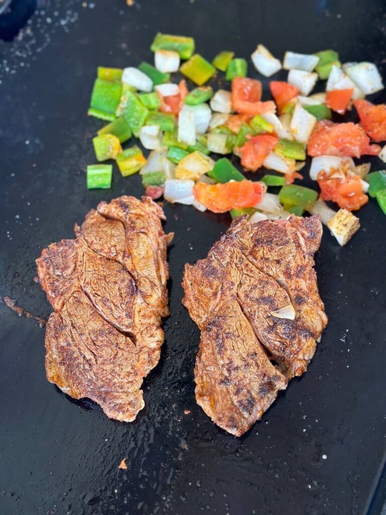 cooking Mexican steak and vegetables on a griddle