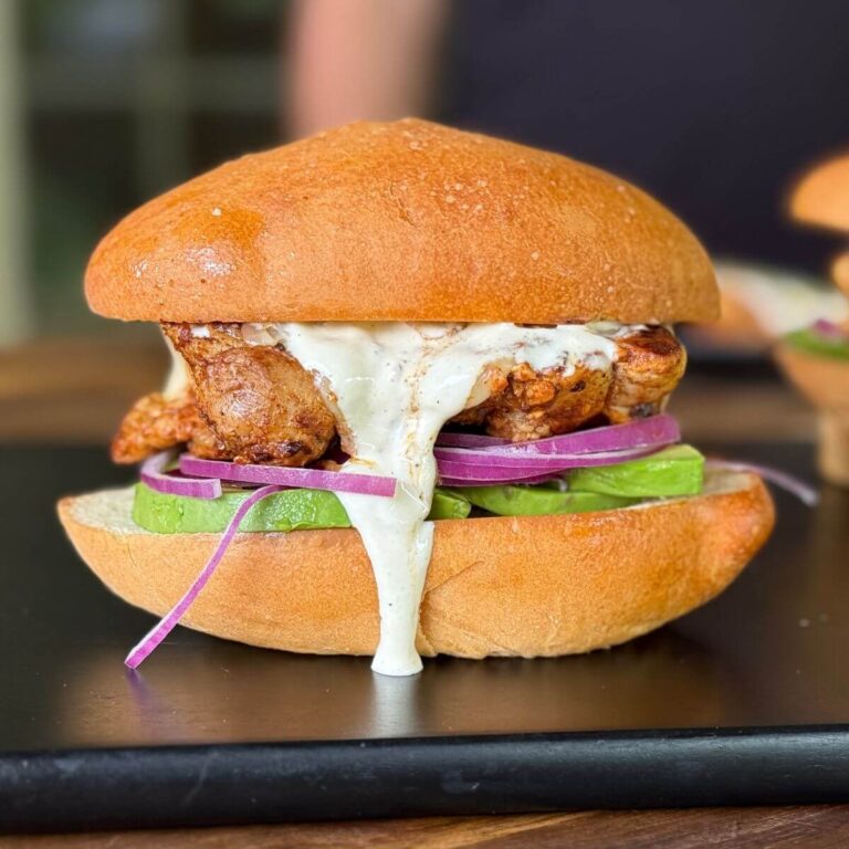 Mexican chicken torta with avocado slices and red onion