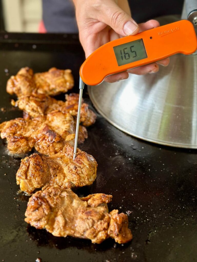 checking the internal temp of chicken with an instant read thermometer
