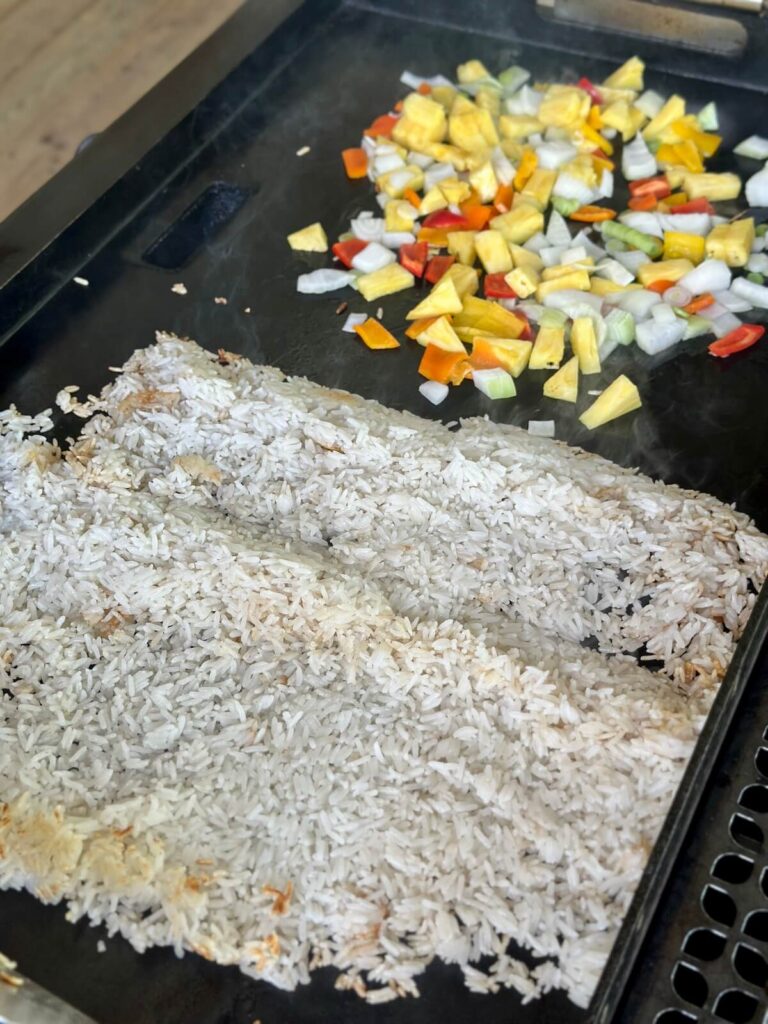 making tropical fried rice on a griddle with jasmine rice and pineapple