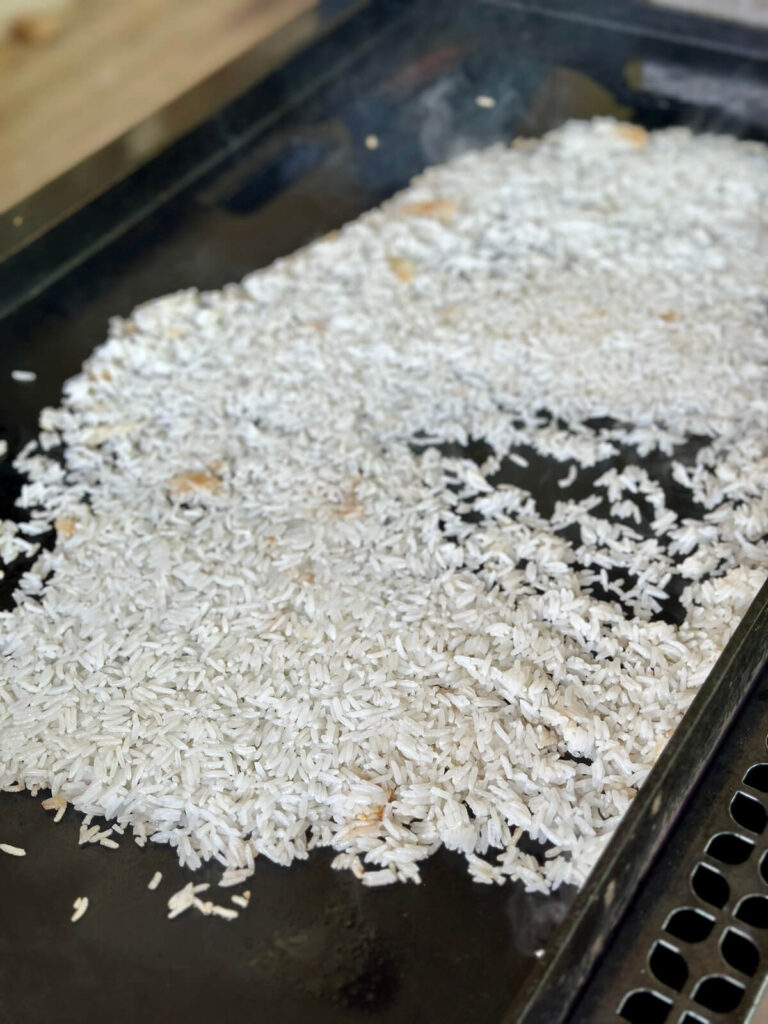 making coconut fried rice on a griddle