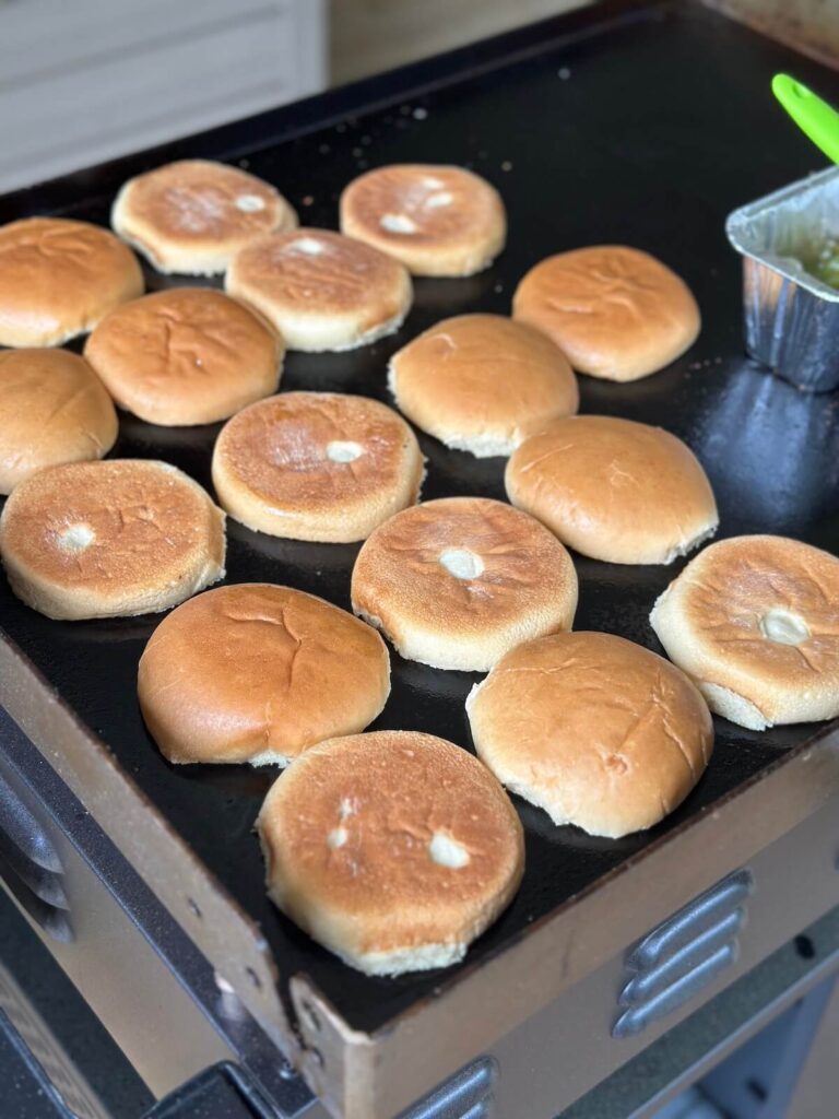toasting hamburger buns on a griddle