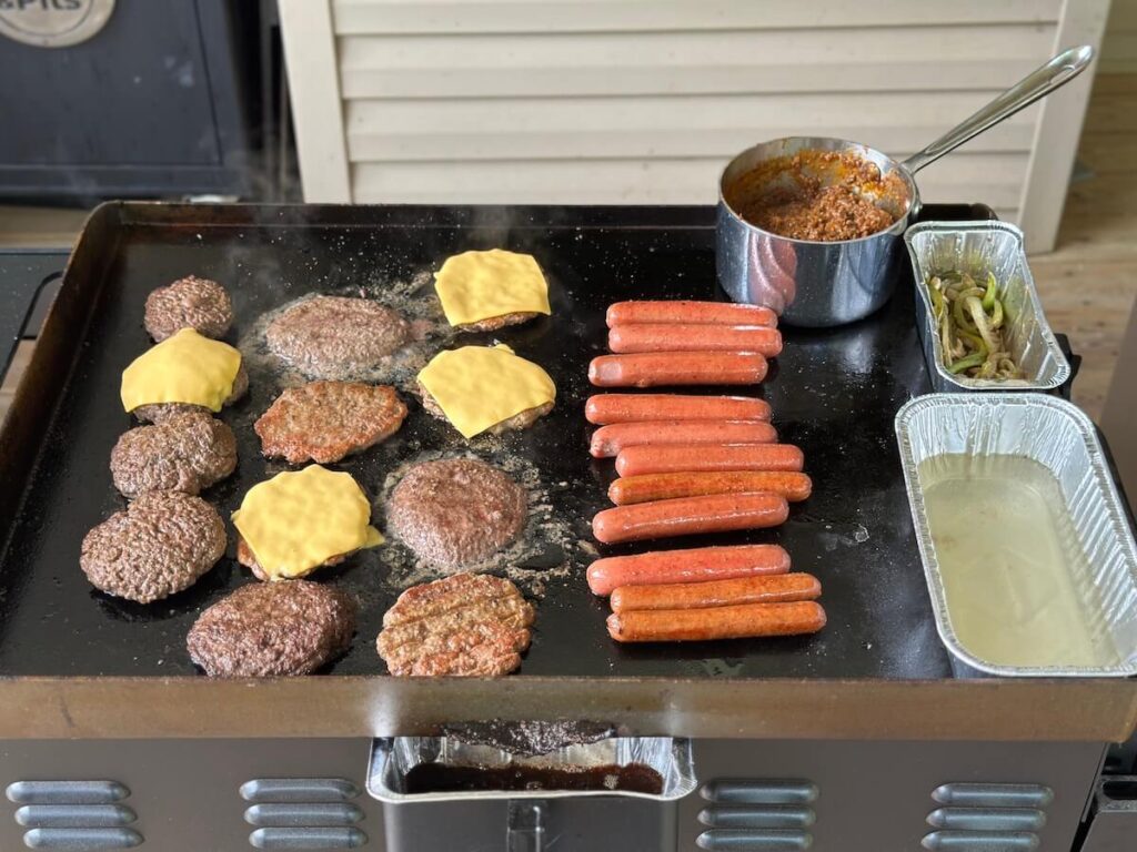 cooking lots of burgers and hot dogs on a Blackstone griddle