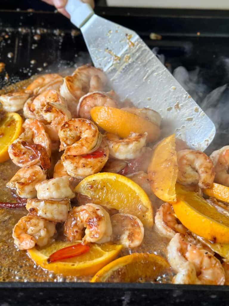 spicy orange shrimp cooking on a griddle
