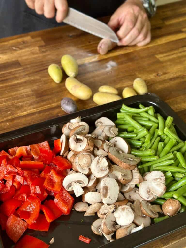 cutting vegetables like mushrooms, bell peppers, and potatoes into bite-sized pieces