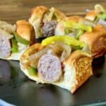 bratwurst sliders on King's Hawaiian buns with peppers and onions
