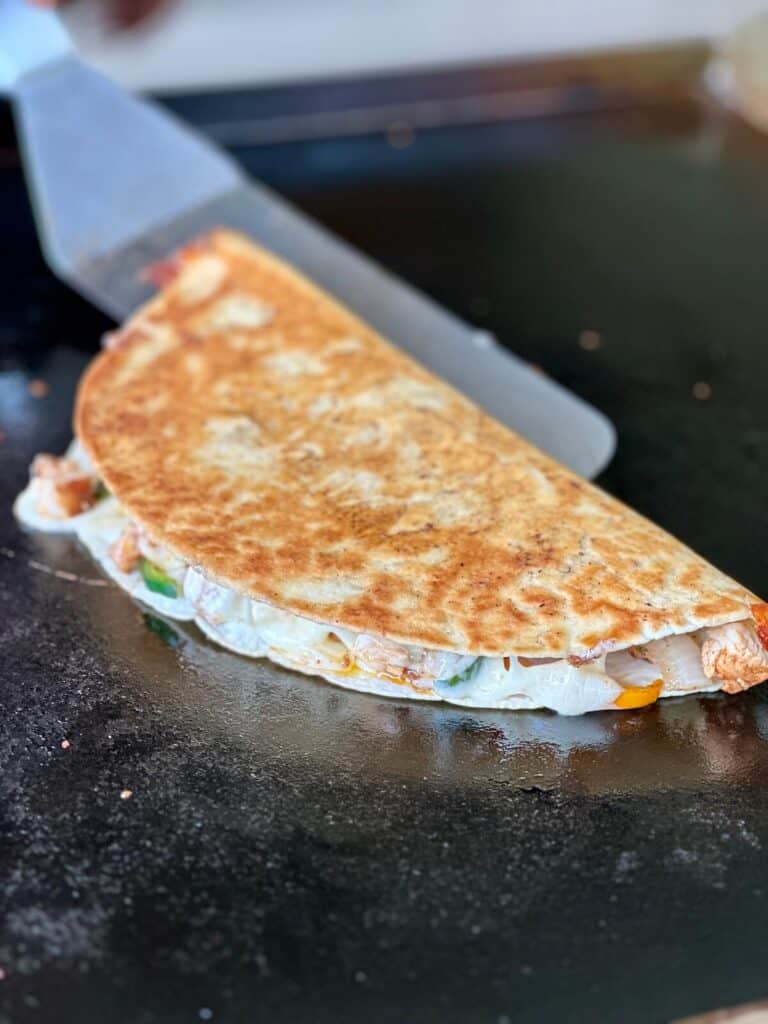 cooking a chicken quesadilla on a Blackstone griddle