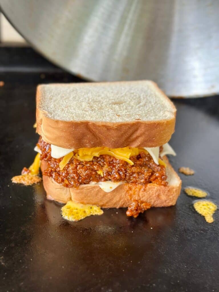 melting cheese on a sloppy joe grilled cheese on the griddle
