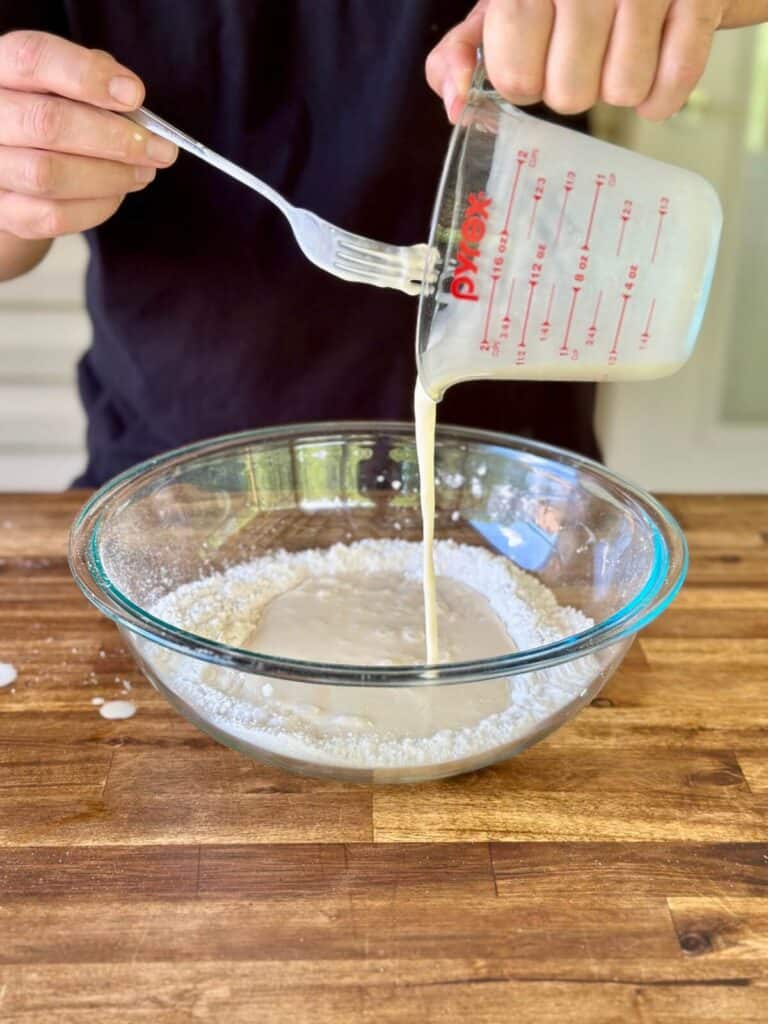 mixing wet ingredients into dry ingredients for homemade pancakes