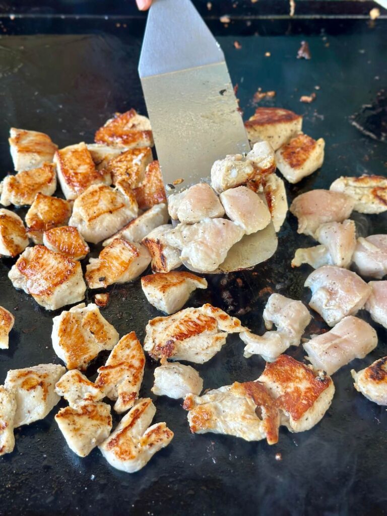 flipping chicken bites to the second side to cook