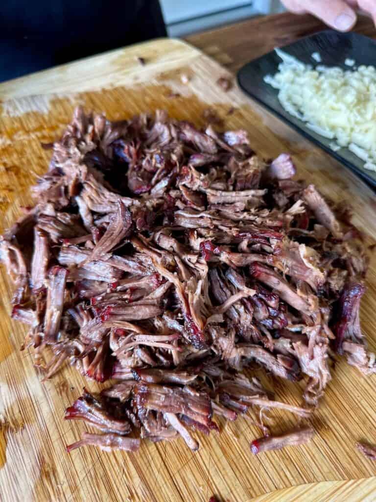 shredded beef on a cutting board