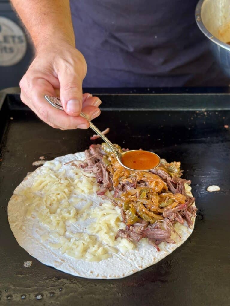making a Mexican shredded beef quesadilla on a griddle