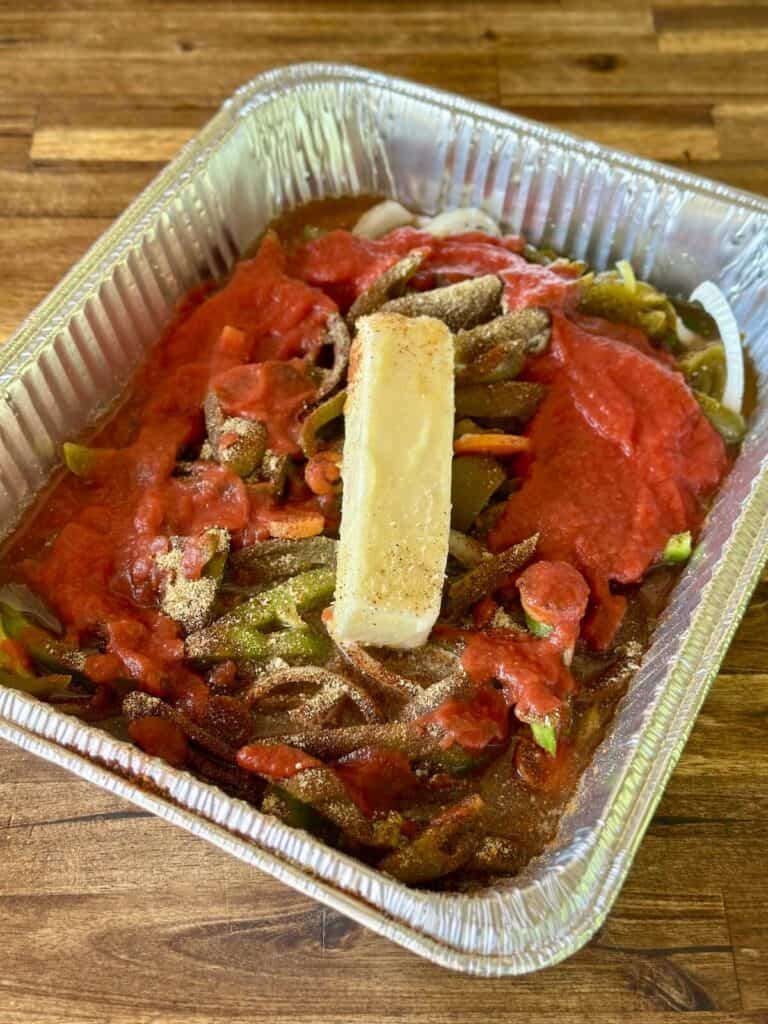 tomato sauce, peppers, onions, and butter in a foil pan