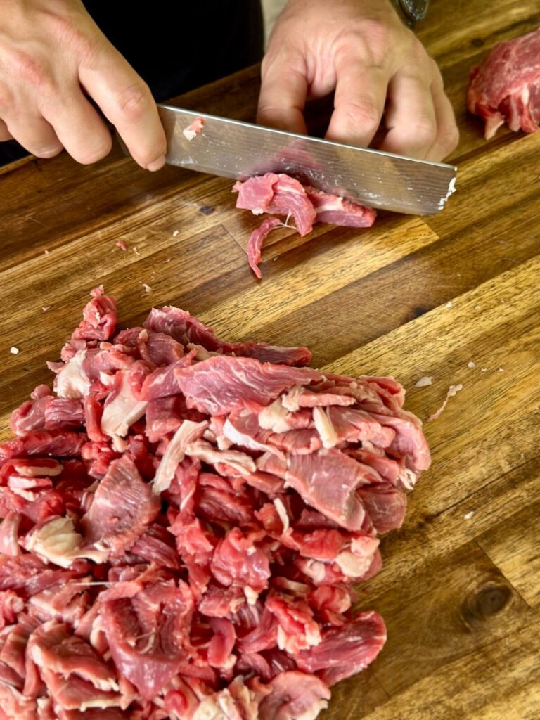 slicing steak into thin strips