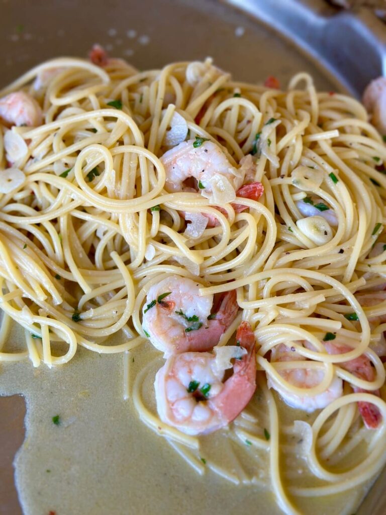 cooking lemon garlic shrimp pasta on a griddle