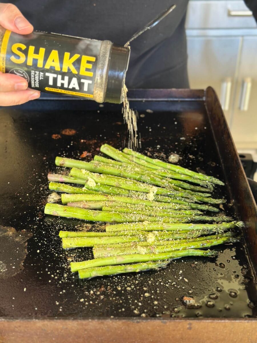 seasoning asparagus on the Blackstone griddle