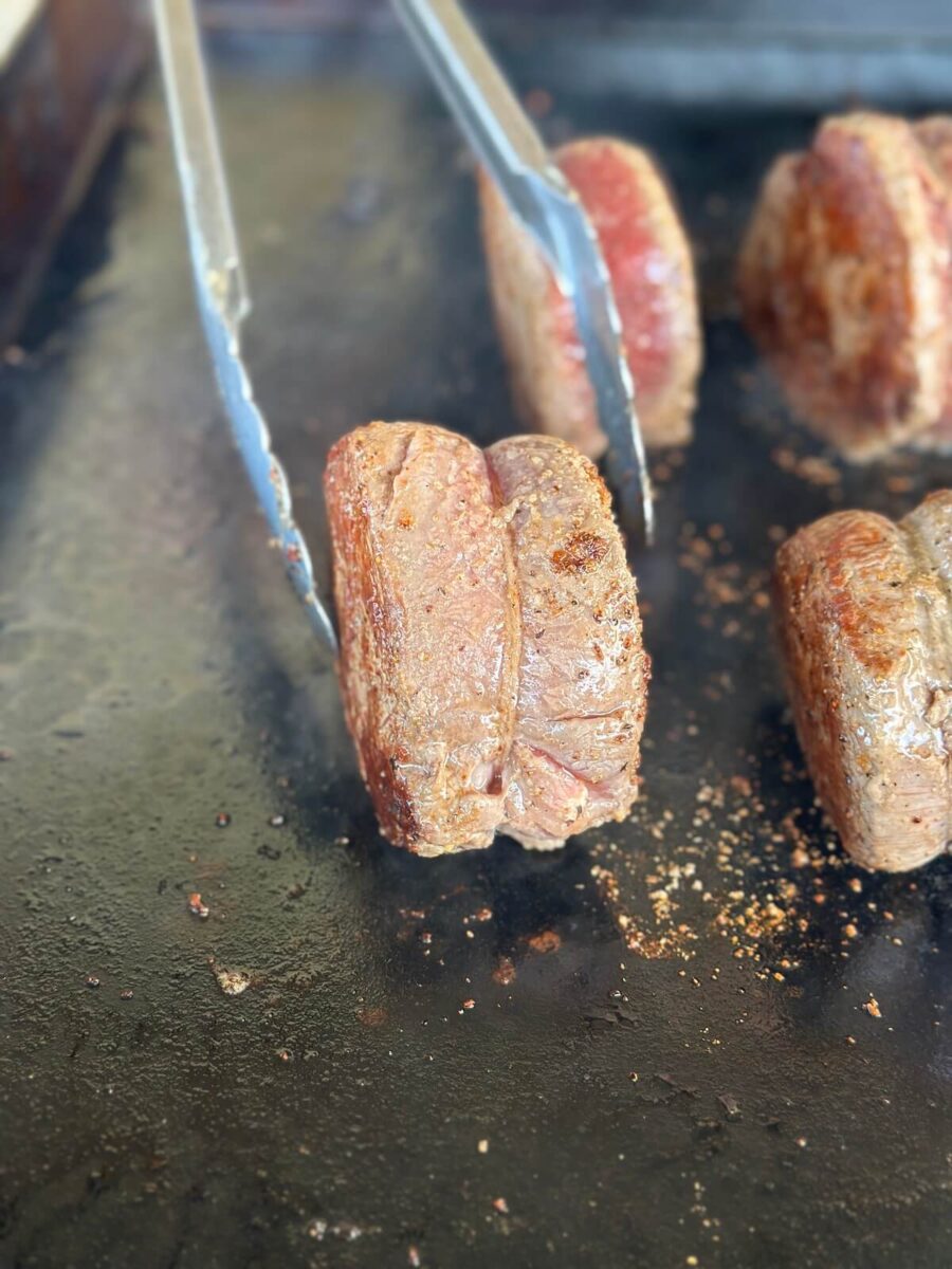 rolling filet on the side on a Blackstone griddle