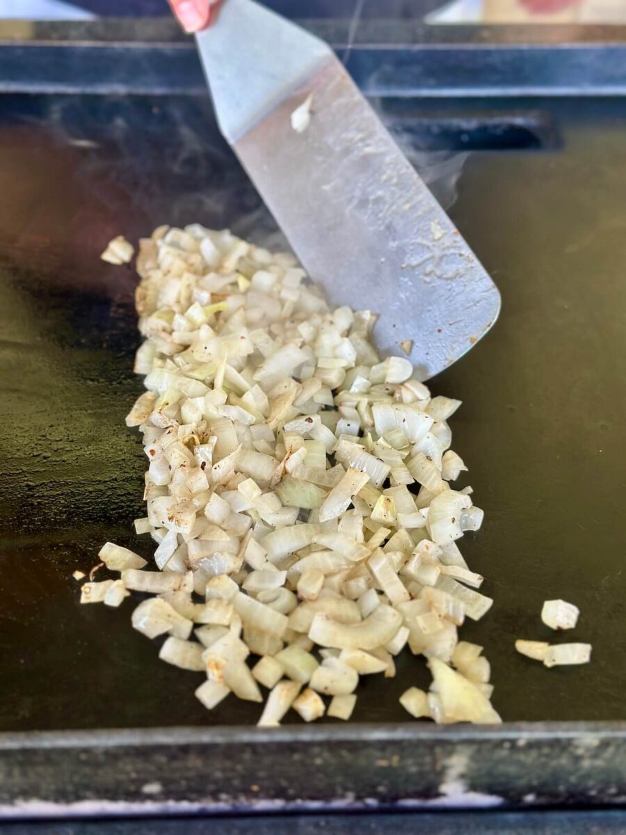 sauteeing diced onions on a griddle