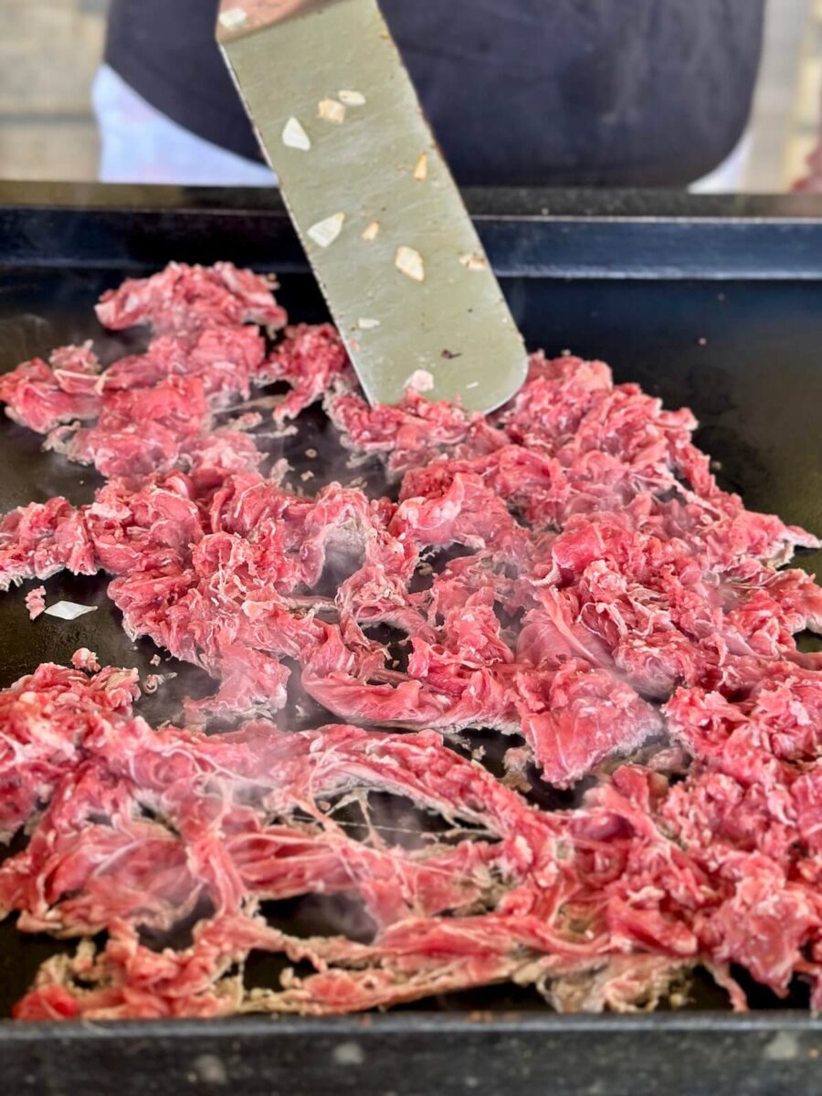 shaved ribeye cooking on a griddle