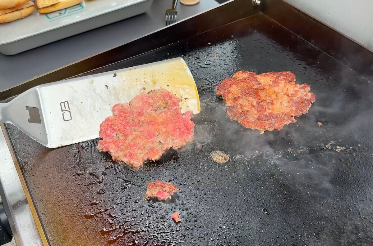 flipping pizza burgers on a griddle