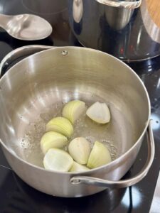 sautéing quartered onions in a pot with beef tallow