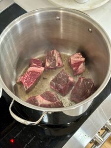 searing chunks of beef chuck roast in a large stock pot