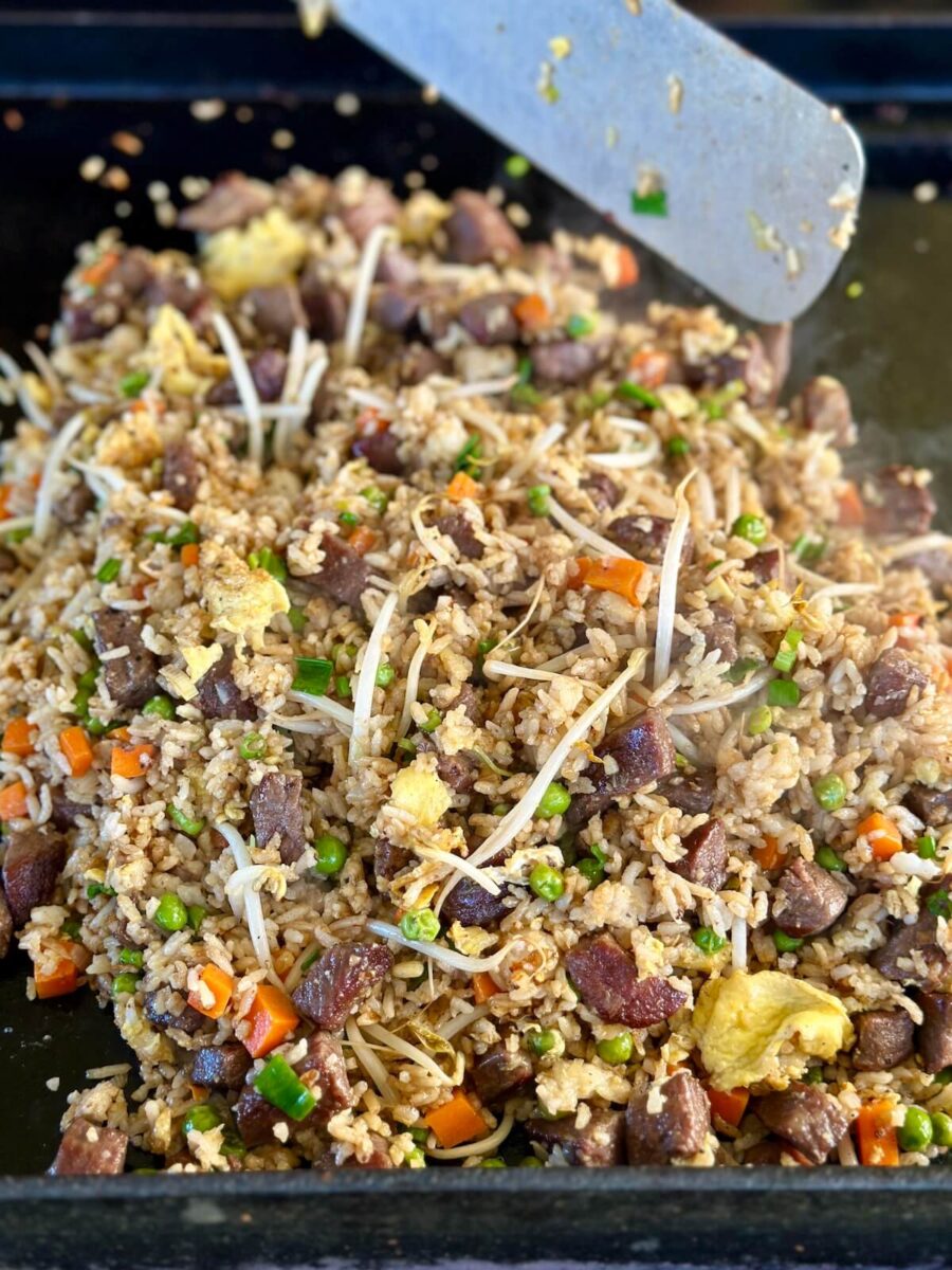 cooking steak fried rice on a griddle