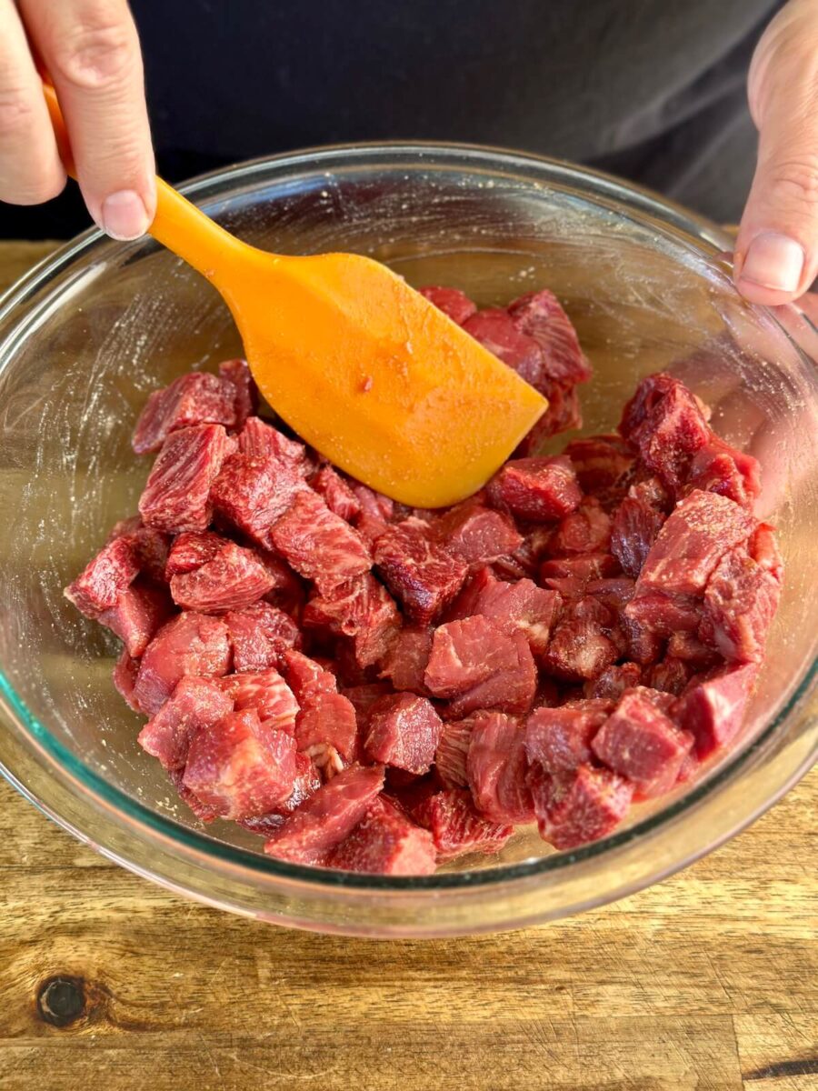 marinating cut pieces of steak in a bowl