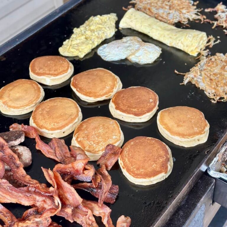 cooking a big breakfast on a Blackstone griddle with bacon, pancakes, hash browns, eggs, and omelettes