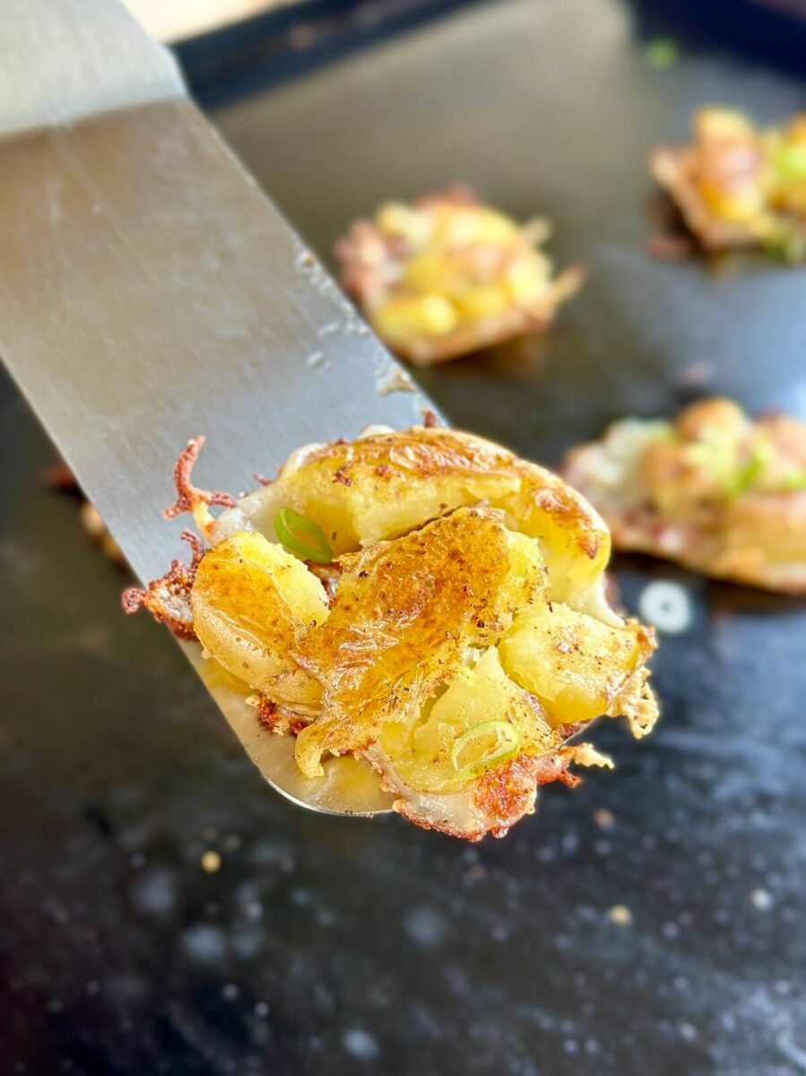 flipping smashed potatoes with a griddle spatula