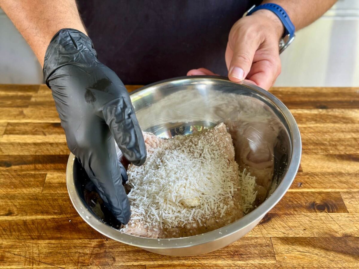 making a mixture of ground chicken in a mixing bowl