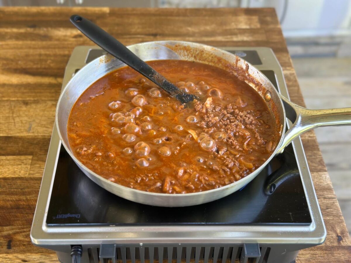 hot dog chili sauce simmering in a large skillet