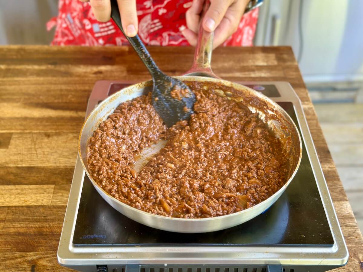 mixing hot dog chili sauce in a large skillet