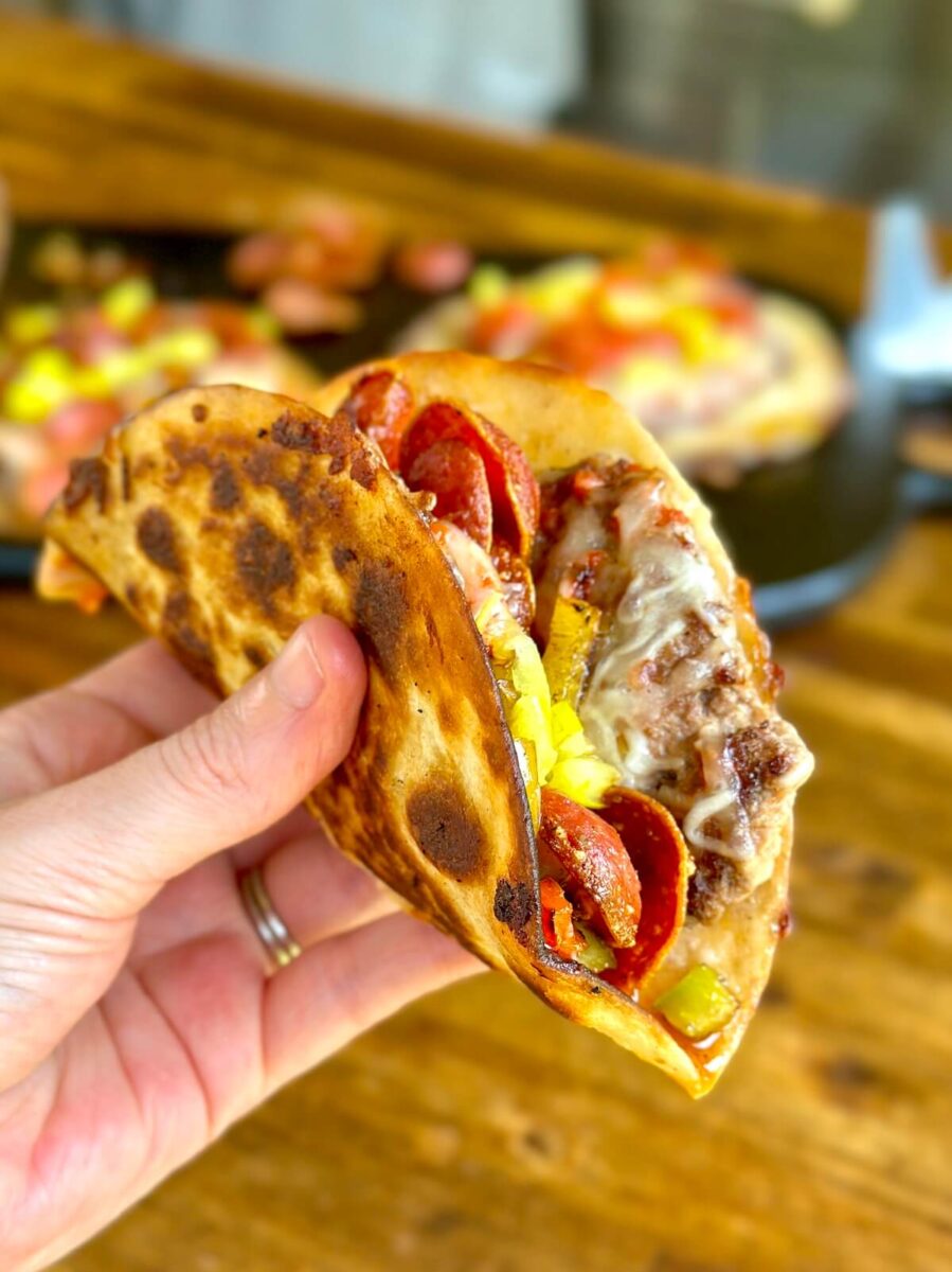 folded pizza taco with mozzarella cheese, ground beef, pepperoni, and banana peppers